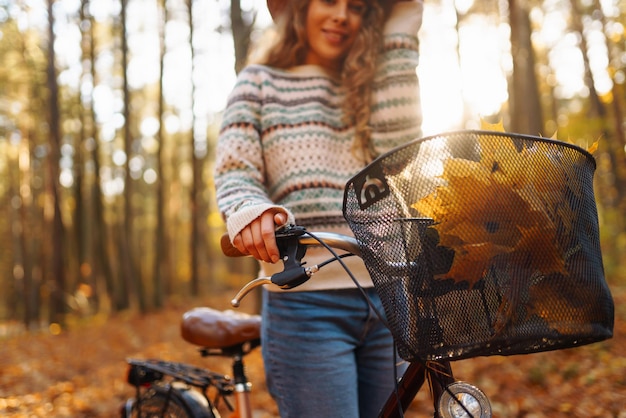 Happy active young woman on bike in autumn park at sunset Concept of people active lifestyle