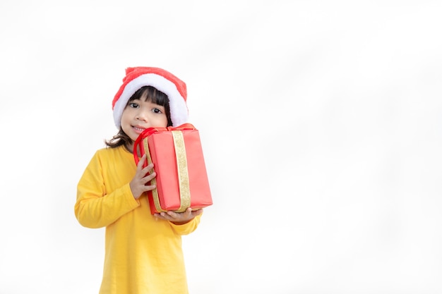 Happy adorable Asian child girl with Christmas gift in hands on white background