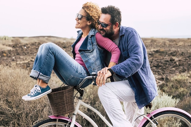 Photo happy adult couple having fun with bicycle