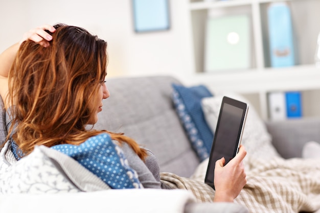 happy adult woman using phone at home in the living room