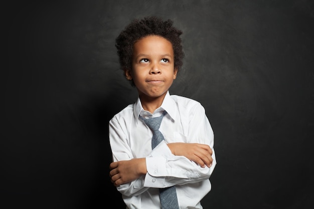 Happy African american child student boy with crossed arms on black portrait