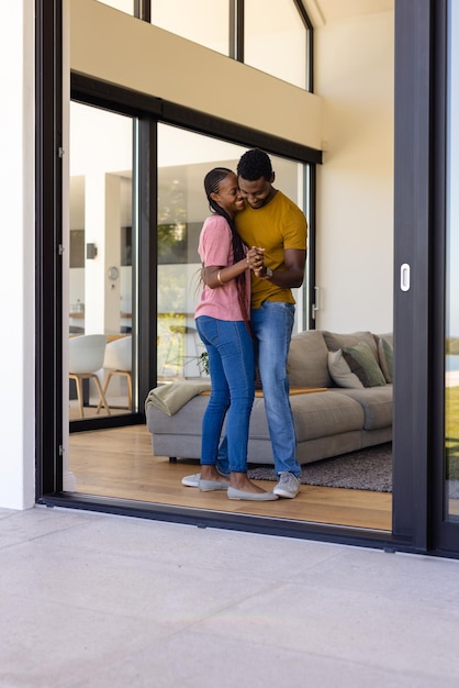 Photo happy african american couple dancing in living room. relaxation, lifestyle, relationship, togetherness and domestic life, unaltered.