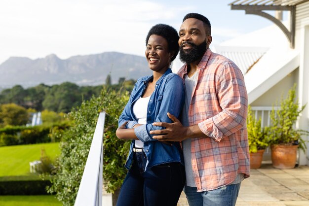 Photo happy african american couple embracing and staying on sunny terrace. lifestyle, nature, family, togetherness and domestic life, unaltered.