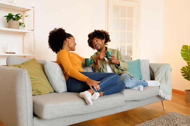 Happy african american couple enjoying relaxing coffee break together indoors