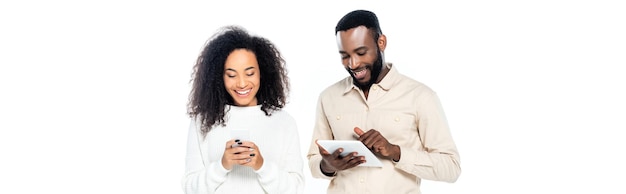 happy african american couple using gadgets isolated on white banner