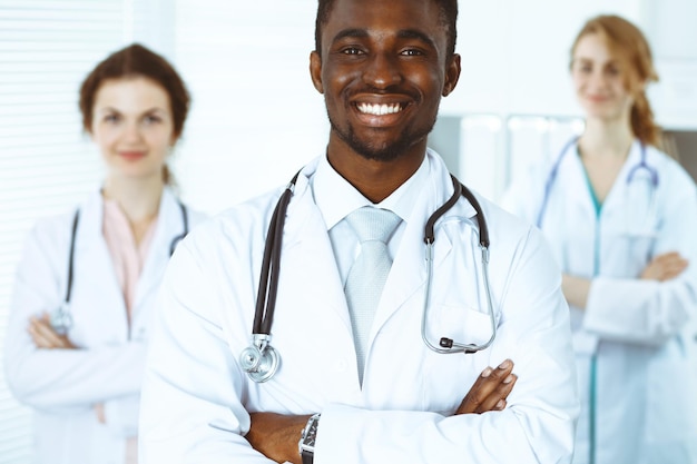 Happy african american doctor with medical staff at the hospital. Multi ethnic people group.