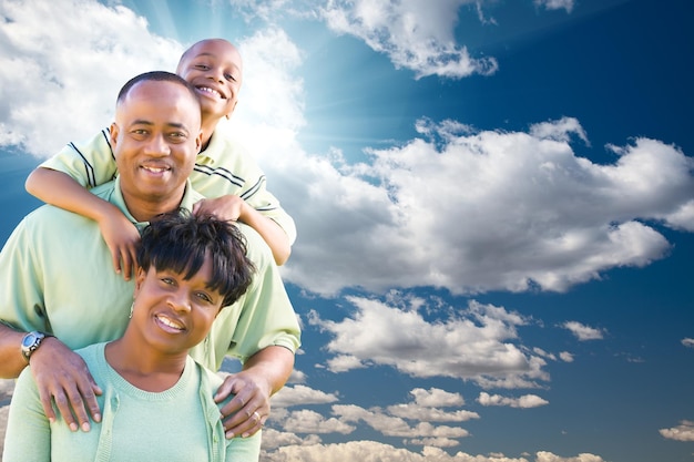 青い空と雲の上で幸せなアフリカ系アメリカ人家族