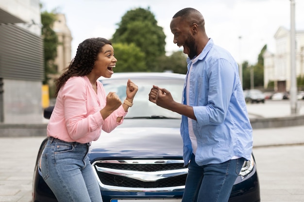 Happy african american family celebrating buying new car