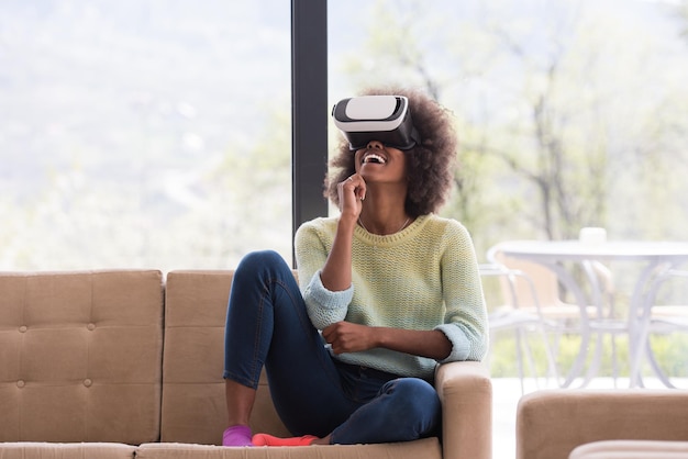 집에서 가상 현실의 VR 헤드셋 안경을 사용하여 경험을 얻는 행복한 아프리카계 미국인 소녀