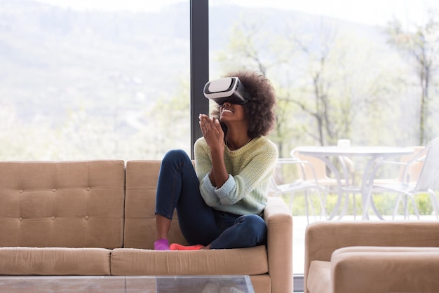 집에서 가상 현실의 VR 헤드셋 안경을 사용하여 경험을 얻는 행복한 아프리카계 미국인 소녀