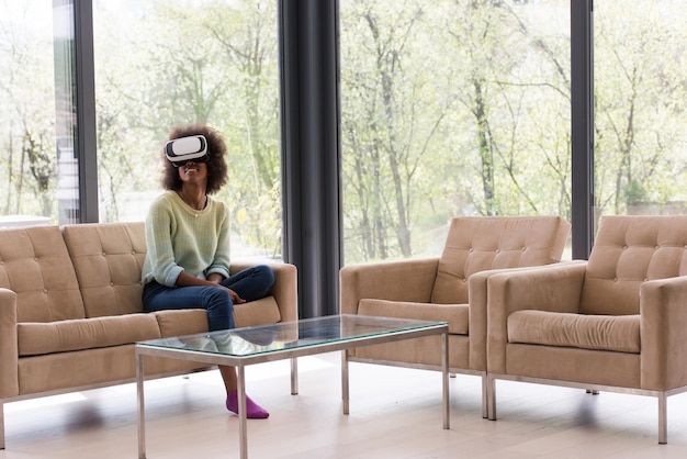 Photo happy african american girl getting experience using vr headset glasses of virtual reality at home