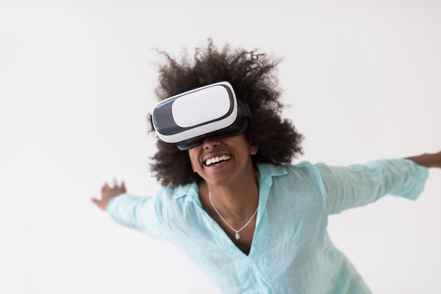 Happy african american girl getting experience using VR headset glasses of virtual reality, isolated on white background