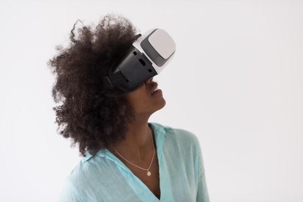 Счастливая африканская американка, получающая опыт использования очков VR-гарнитуры виртуальной реальности, изолированных на белом фоне
