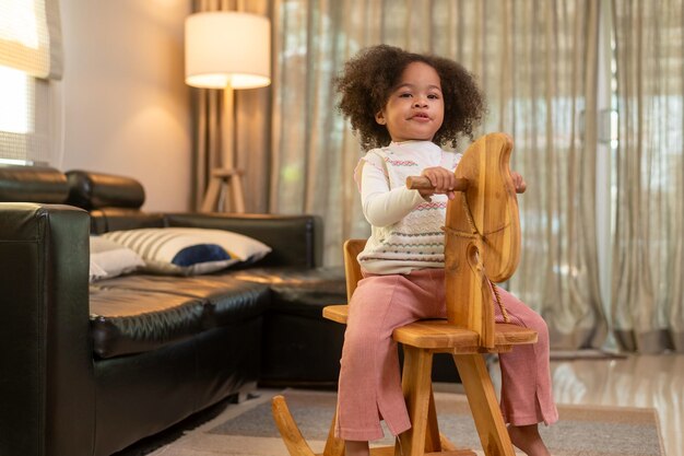 Happy African American girl playing in living room at home