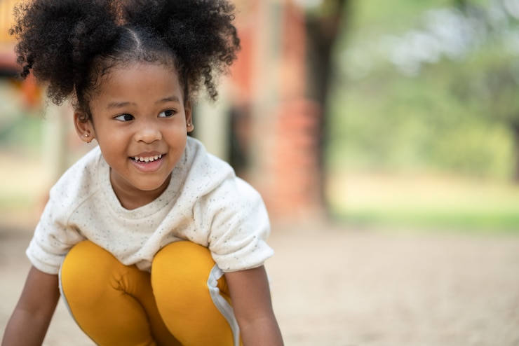 Photo happy african american little girl smiling at playground in the park