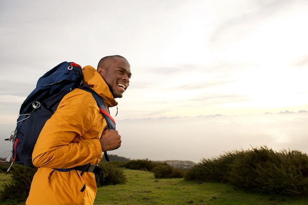 Happy african american male backpacker walking outdoor in nature