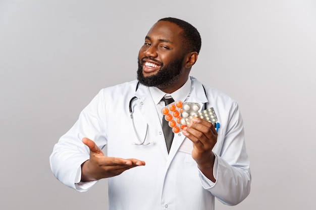 Premium Photo | Happy african-american male doctor in white coat present  new drugs, cure from disease
