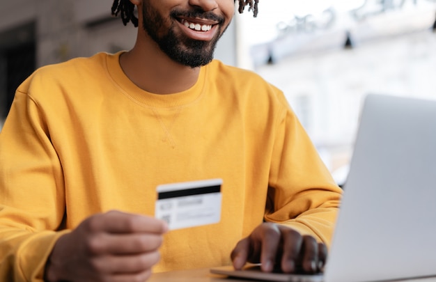 Happy African American man holding credit card