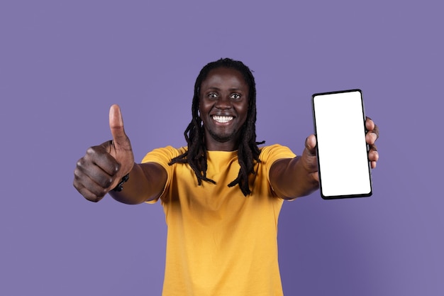 Happy african american man showing smartphone and thumb up