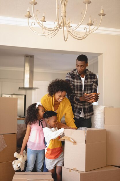 Photo happy african american parents with their children packing their belongings in living room