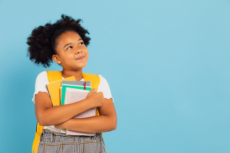 Photo happy african american schoolgirl holding books on blue background back to school concept