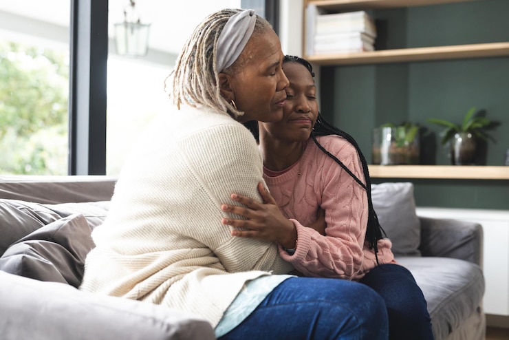 Photo happy african american senior mother and adult daughter sitting on couch and embracing
