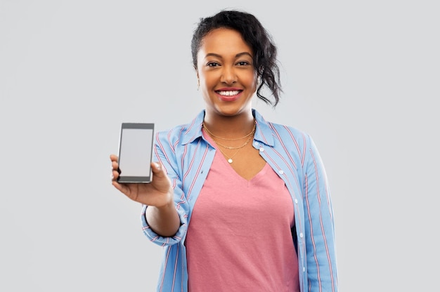 happy african american woman showing smartphone