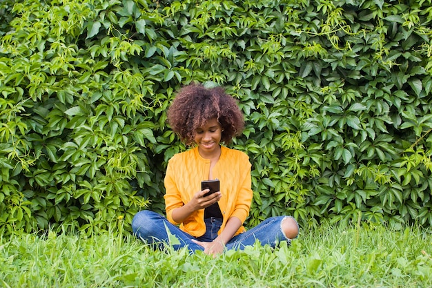 電話で話している通りで幸せなアフリカ系アメリカ人の女性