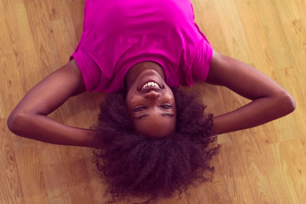 필라테스 운동 후 휴식을 취하는 체육관에서 곱슬머리 아프로 헤어스타일을 한 행복한 아프리카계 미국인 여성