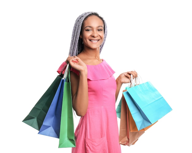 Happy African-American woman with shopping bags on white