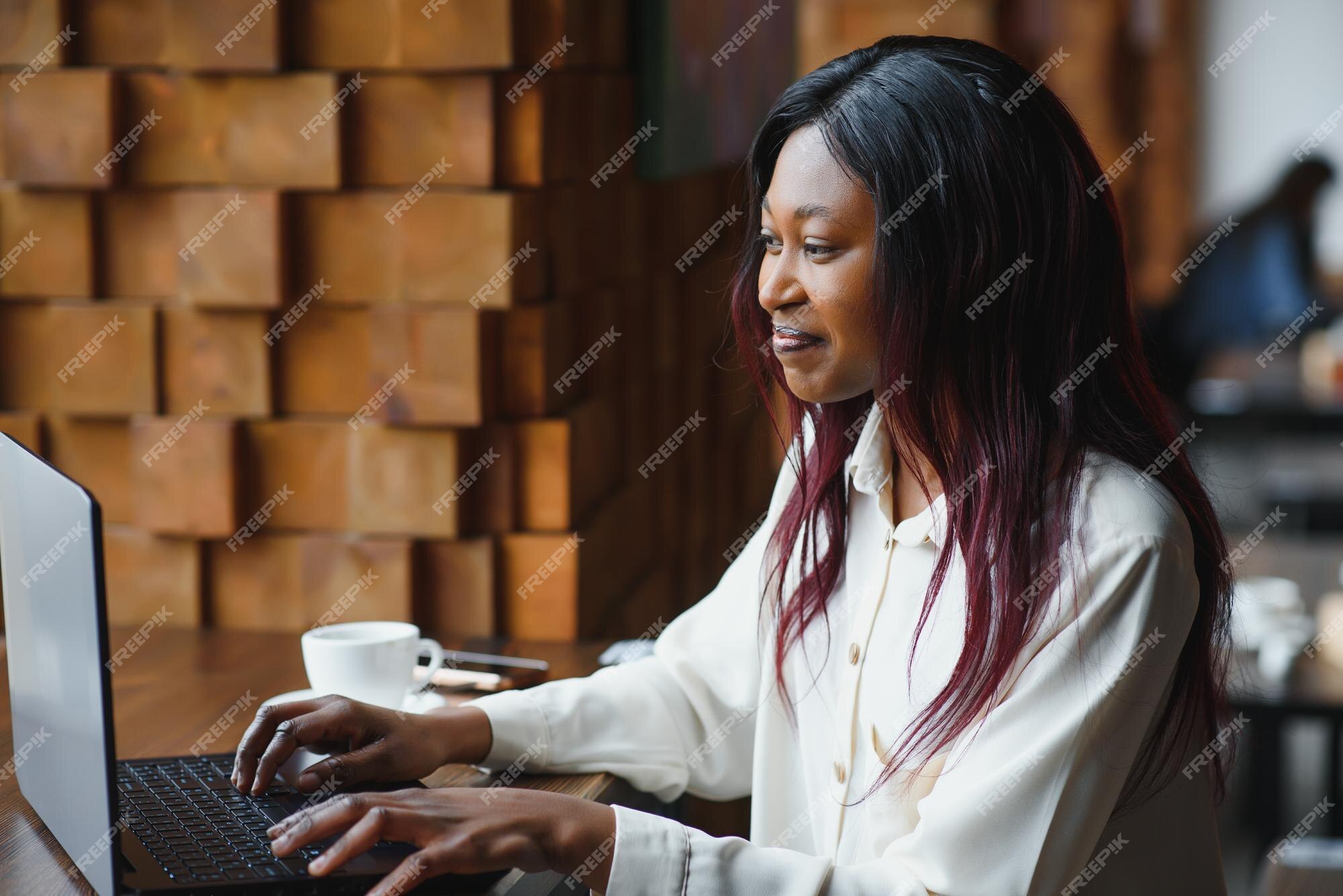 mixed race young woman typing on computer keyboard at table with