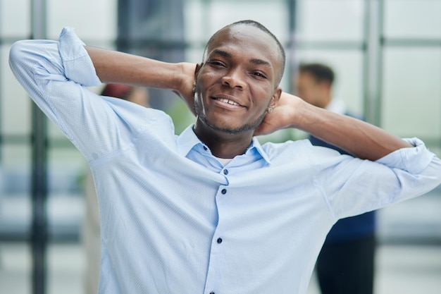 Happy african american young businessman holding his hands behind his head