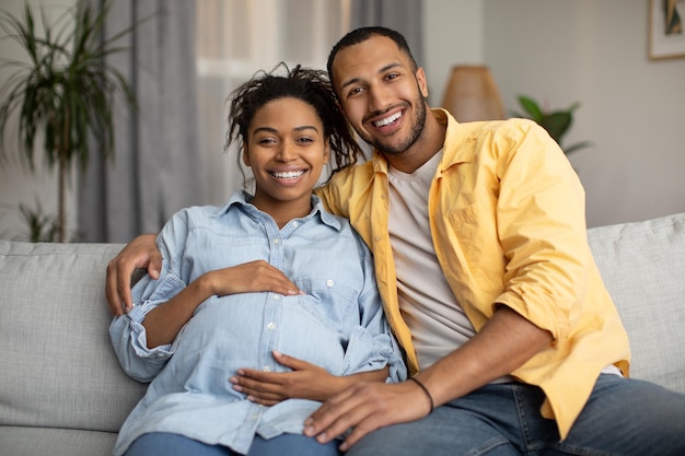 Happy African American Young Couple Embracing Smiling To Camera Indoor