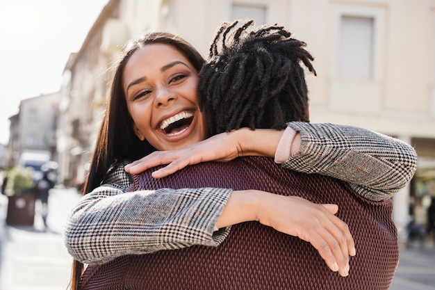 Photo happy african couple having fun hugging outdoor in the city - focus on girl face