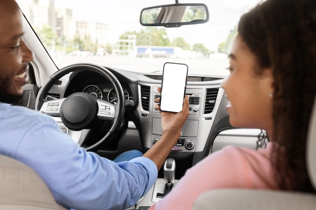 Happy african couple using showing smartphone with empty screen