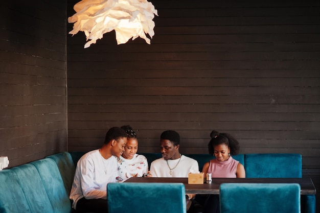 カフェで座ってチャットしている幸せなアフリカの友人レストランで会う黒人のグループ