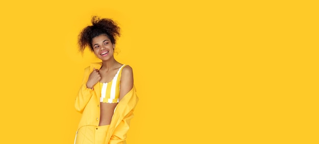 Happy african girl wear stylish yellow clothes on studio background banner