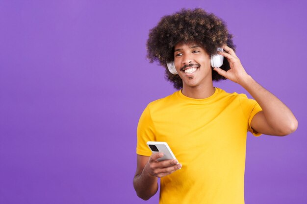 Happy african man listening music with headphones and a mobile