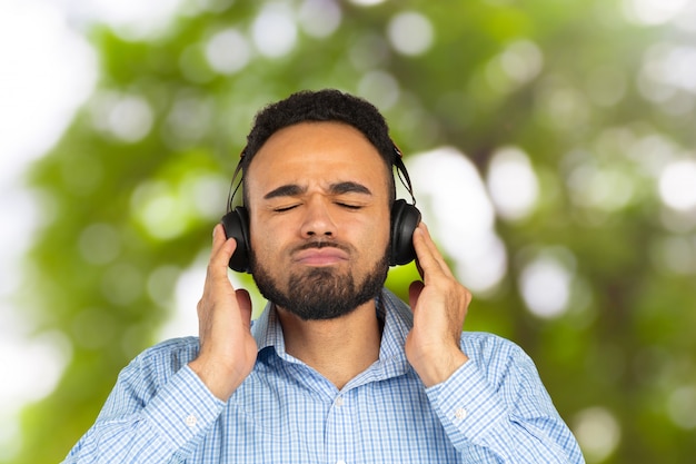 Happy african man smiling listening to music in headphones