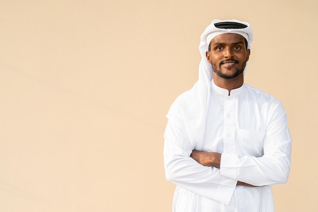 Happy African Muslim man wearing religious clothing an scarf with arms crossed