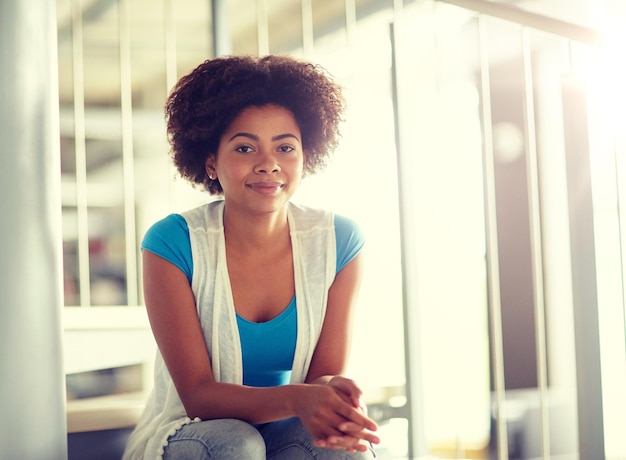 Photo happy african student girl sitting on stairs