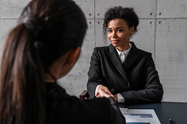 写真 オフィスで握手する幸せなアフリカの女性