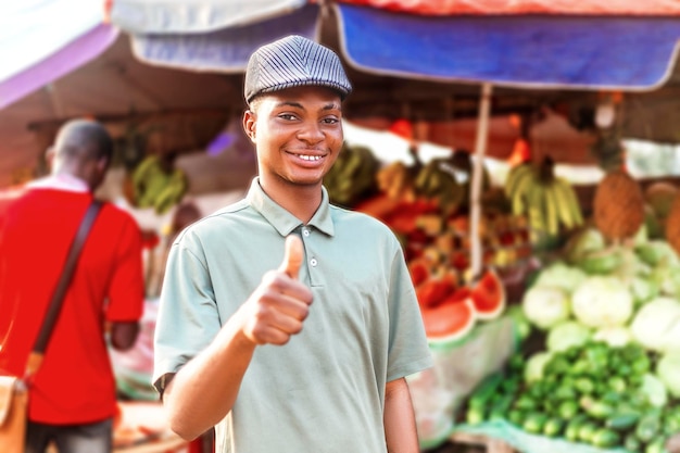 happy African young trader smiling raising thumb up in fruit market