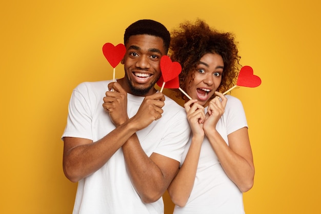 Happy africanamerican couple holding red paper hearts