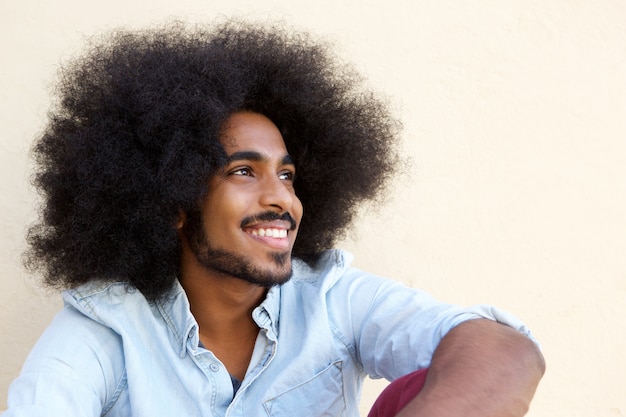 Happy afro man sitting and looking away