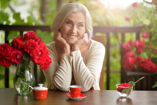 Happy aged woman drinking coffee at home