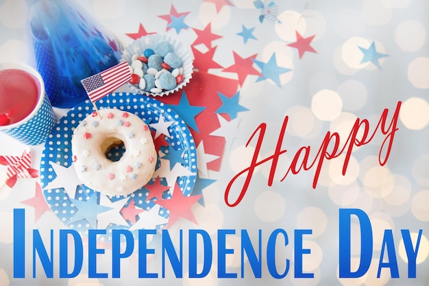 幸せなアメリカ独立記念日、お祝い、愛国心、祝日のコンセプト – 7月4日のパーティーで、使い捨ての食器にジュースドリンクとキャンディーを入れたドーナツを上からクローズアップ