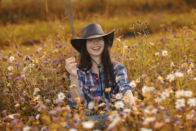 Happy American woman in a cowboy hat field wild flowers