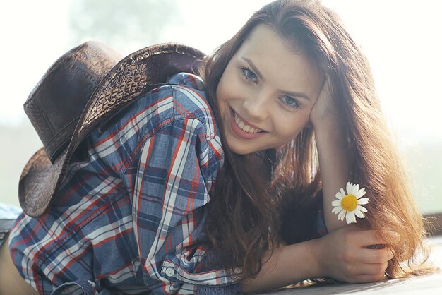 Happy american woman in a cowboy hat field wild flowers