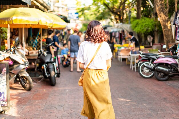 Счастливая и красивая азиатская женщина путешествуя на khao sarn road, таиланде